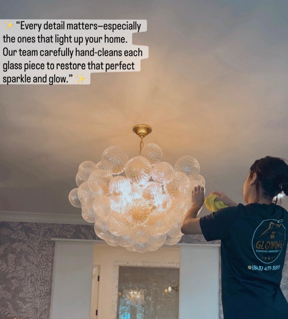 A professional cleaner from Glowing Cleaning Services polishing an ornate chandelier in a home in North Charleston, SC.