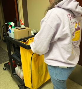A cleaner from Crabby Cleaners pushing a fully stocked cleaning supply cart at a job site in Mount Vernon, KY