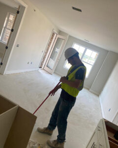 A cleaner from Gem City Commercial and Residential Cleaning sweeping an empty room during post-construction cleanup in Dayton, OH