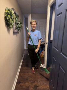 A cleaner from Crabby Cleaners sweeping a hallway with a broom, showing dust on the floor in Mount Vernon, KY