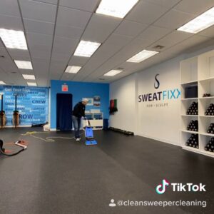 A cleaner using a floor buffer in a gym for Clean Sweeper Cleaning Services in Melrose, MA