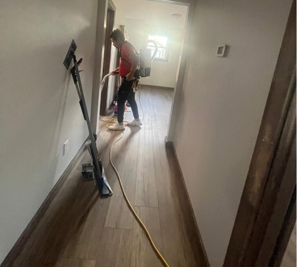 A cleaner from Clean Corp Indiana using a floor cleaning machine in a residential hallway in Bloomington, IN.