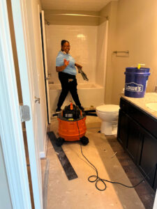 A cleaner from Gem City Commercial and Residential Cleaning vacuuming a bathroom during a post-construction cleanup in Dayton, OH