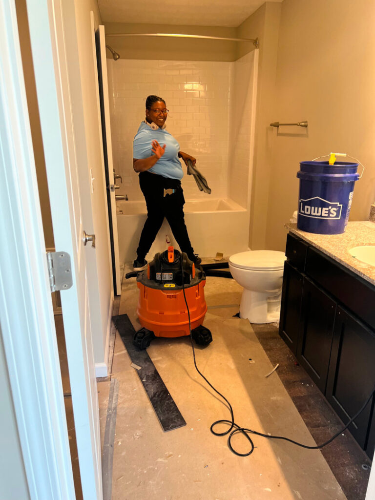 A cleaner from Gem City Commercial and Residential Cleaning vacuuming a bathroom during a post-construction cleanup in Dayton, OH