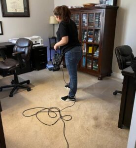A house cleaner from Denver MOP STARS Cleaning Service vacuuming a carpeted room in Denver, CO.