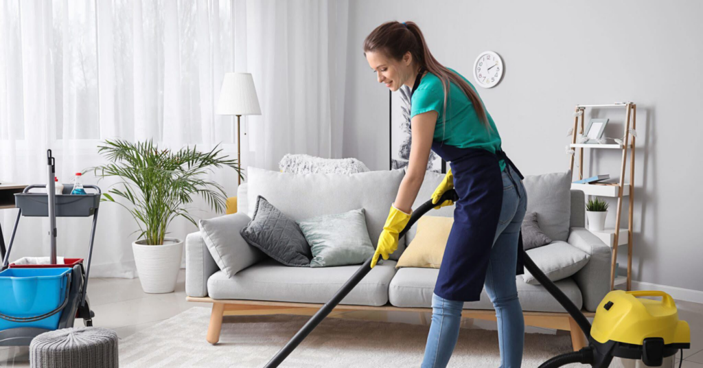 A professional cleaner vacuuming a living room for The Cleaning Genie, LLC in Olive Branch, MS.