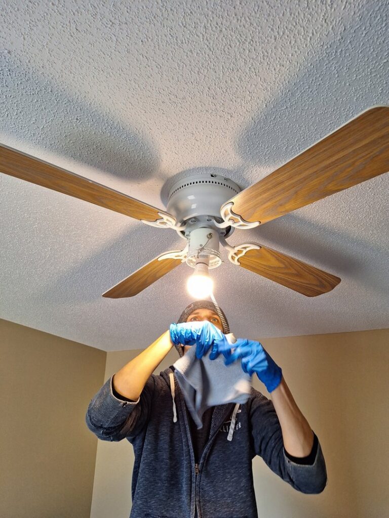 A cleaner from Absolute Luxury, LLC Residential & Commercial Cleaning meticulously wipes down a ceiling fan in Antioch, TN.