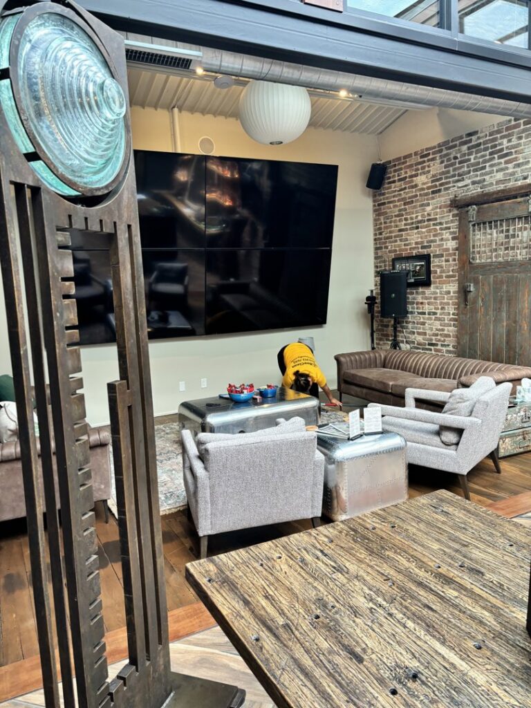 A professional cleaner from Bee Clean Solutions wiping a coffee table in a lounge area in Lexington, KY.