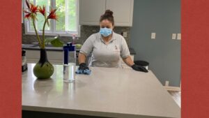 A cleaner from Bivian's Cleaners LLC wiping a kitchen counter with a cloth in Trenton, NJ.