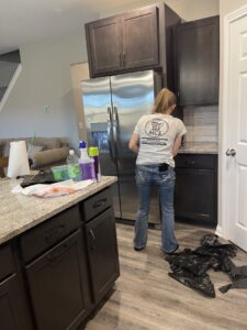 A Maximo Cleaning professional in Lexington, KY, wiping down a kitchen counter during a house cleaning service.