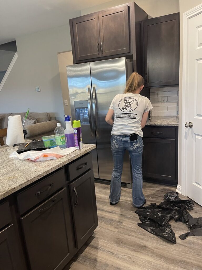 A Maximo Cleaning professional in Lexington, KY, wiping down a kitchen counter during a house cleaning service.