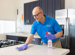 A professional cleaner from Presto Cleaning wiping a kitchen counter in San Diego, CA.