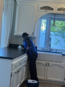 A cleaner from Fabylous Cleaning Service wiping a kitchen countertop in Anaheim, CA.