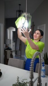 A professional cleaner from Picky Performance Cleaning wiping a light fixture in a kitchen in North Las Vegas, NV
