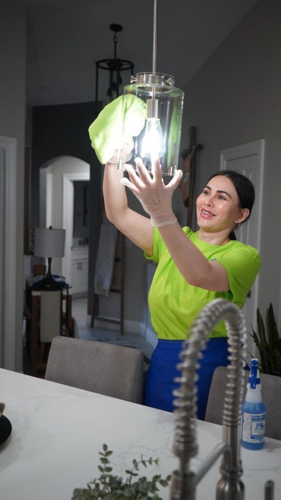 A professional cleaner from Picky Performance Cleaning wiping a light fixture in a kitchen in North Las Vegas, NV