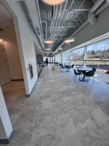 A cleaner pushing a yellow cleaning cart down a long hallway, demonstrating services by Statewide cleaning services llc in Philadelphia, PA.