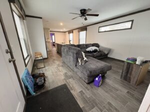 A purple cleaning product bottle on the floor in a living room, indicating cleaning work by Heavenly Harlots Maid Cleaning Services in Grand Forks, ND.