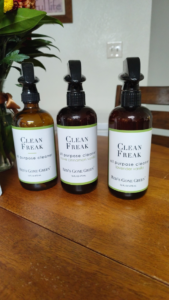 Three bottles of all-purpose cleaning products on a wooden table, used by Precision Residential Cleaning in Dallas, TX