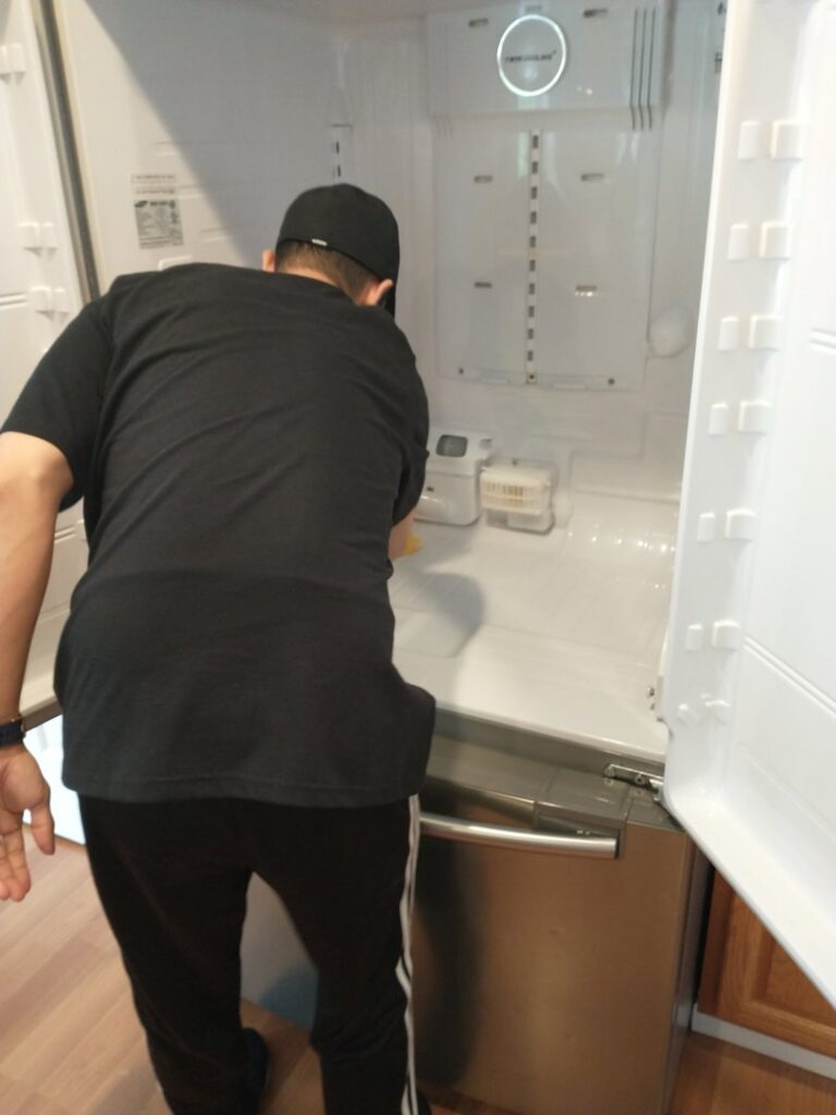 A professional cleaner from Leave The Dust To Me Cleaning Services LLC in Anchorage, AK, cleaning the interior of a refrigerator.