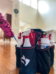 A cleaning supplies caddy with spray bottles and a duster, ready for house cleaning by So Clean Cleaning Services in East Providence, RI.