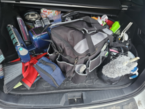 A car trunk packed with various cleaning supplies and equipment for Mountain Life Services LLC in Colorado Springs, CO.
