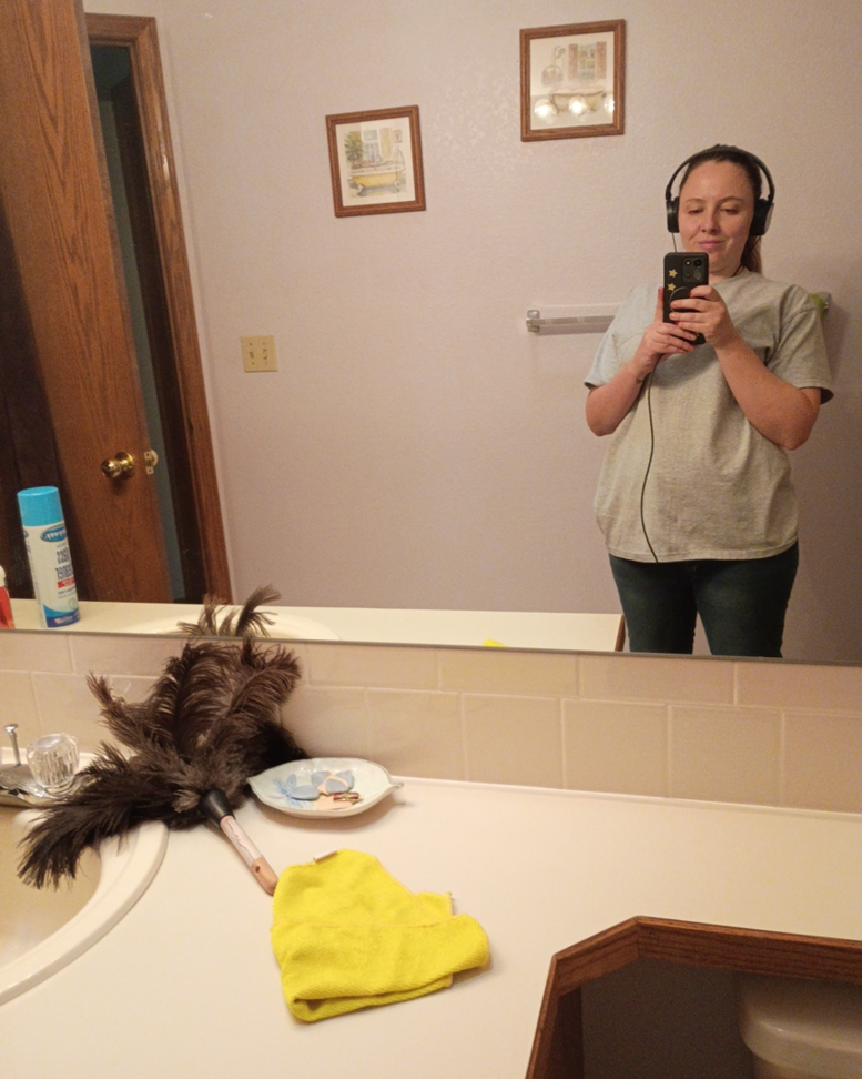 Cleaning tools like a duster, cloth, and spray bottle on a bathroom counter by Root and Sky Cleaning in Fort Collins, CO.