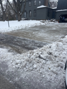 A residential driveway and sidewalk completely cleared of snow by Jmccllm landscaping lawn care, junk removal in Springfield, IL.
