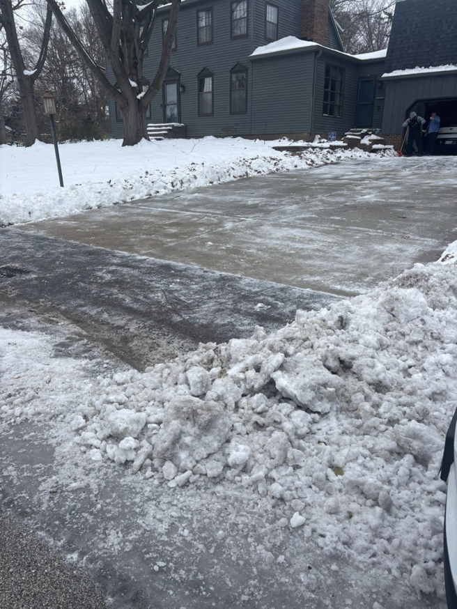 A residential driveway and sidewalk completely cleared of snow by Jmccllm landscaping lawn care, junk removal in Springfield, IL.