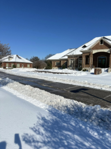 A cleared driveway with snow piled on the sides, indicating professional snow removal services by Hays Landscape Solutions LLC in Jackson, TN.