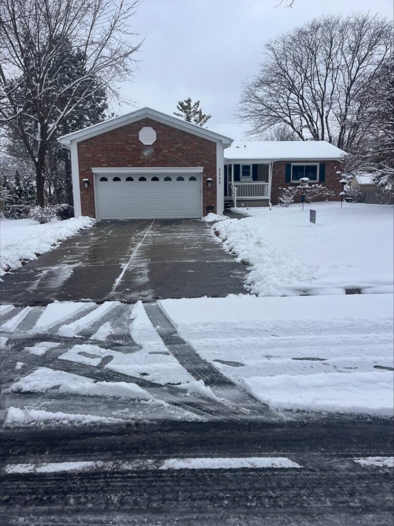 A residential driveway partially cleared of snow by Snow Scholars - Snow Removal By College Students in Madison, WI.