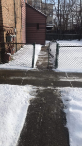 A cleared concrete path next to a building after snow removal by Apolonio's Snow Removal and Lawn care in Chicago, IL.