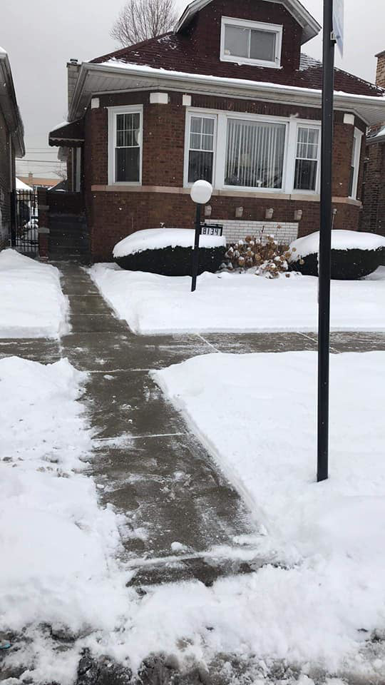 A cleared sidewalk in front of a residential home after snow removal by Apolonio's Snow Removal and Lawn care in Chicago, IL.