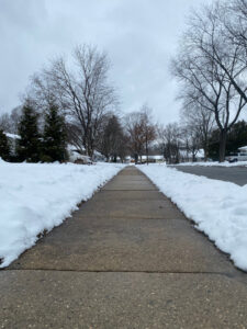 A residential sidewalk completely cleared of snow by Snow Scholars - Snow Removal By College Students in Madison, WI.