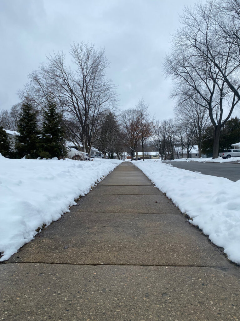 A residential sidewalk completely cleared of snow by Snow Scholars - Snow Removal By College Students in Madison, WI.