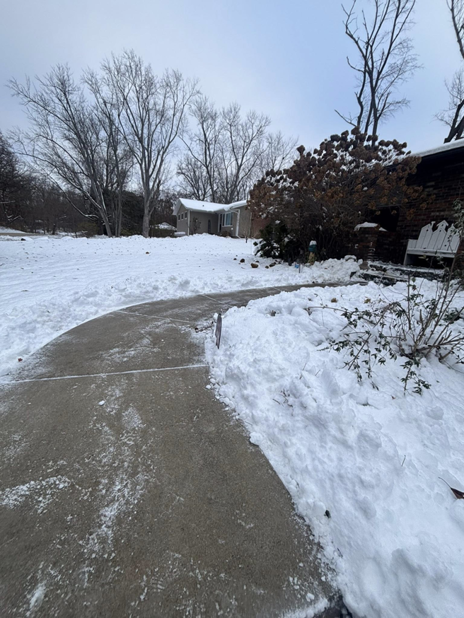 A residential sidewalk and path cleared of snow by Jmccllm landscaping lawn care, junk removal in Springfield, IL.