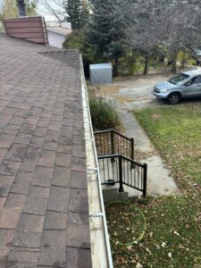 A clogged gutter on a residential roof, indicating a need for water damage prevention services from 307 HomeWorks in Gillette, WY.