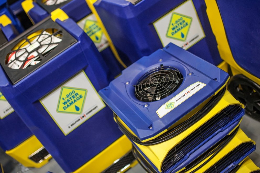 A close-up view of blue and yellow air movers, essential water damage equipment used by 1-800 WATER DAMAGE of Oklahoma City, OK.