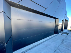A close-up view of a sleek black modern garage door, a project by Windsor Door Sales Inc. in Ogden, UT.