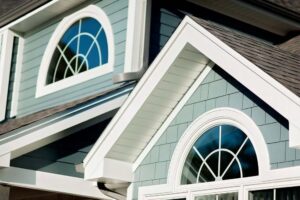 Close-up of a home's exterior with blue siding and white trim by SmardBuild Siding and Exteriors in Naperville, IL