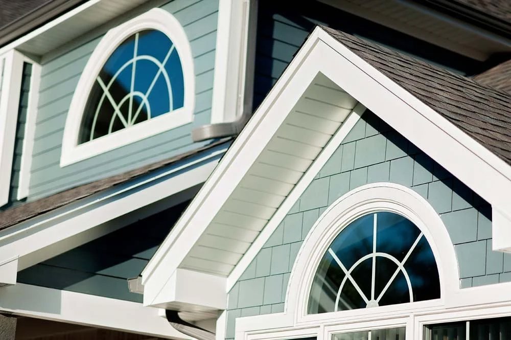 Close-up of a home's exterior with blue siding and white trim by SmardBuild Siding and Exteriors in Naperville, IL