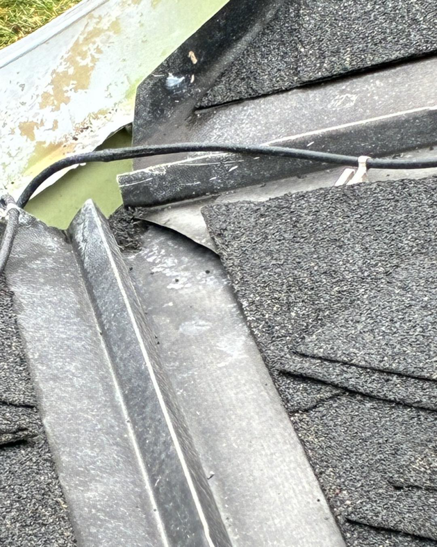 A close-up view of damaged roof flashing and gutter, showing a potential water entry point, by Barbera Home Improvement in Parma, OH.
