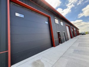 A close-up view of a dark panel garage door on a commercial building, installed by YETI Garage Door in Moorhead, MN.