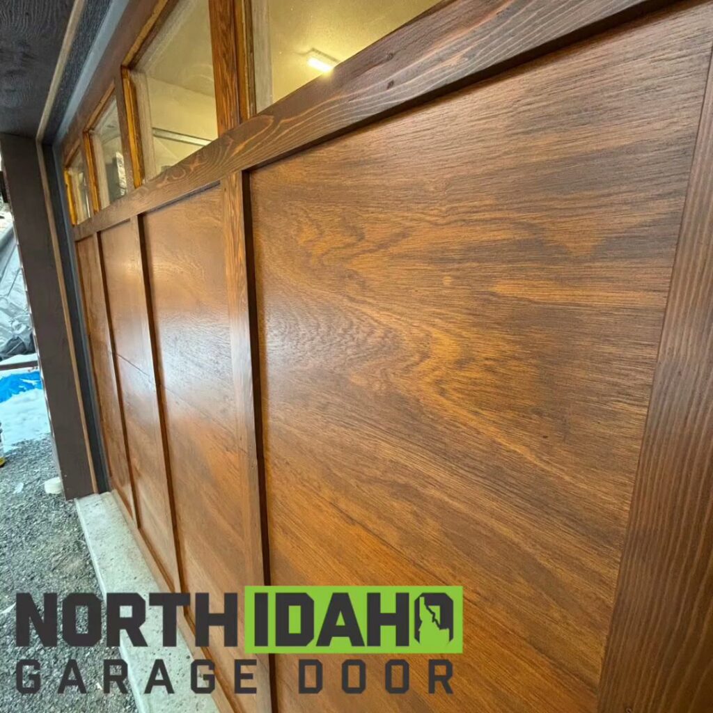 Close-up view of a newly installed wood grain garage door, highlighting its texture and finish by North Idaho Garage Door in Coeur d'Alene, ID.