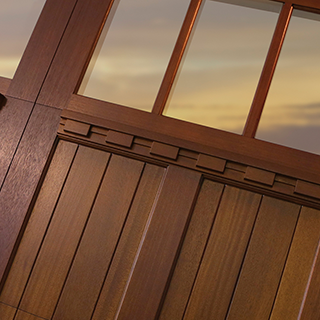 A close-up view of a stylish wooden garage door section with windows by Advance Garage Door, Inc. in Fargo, ND.