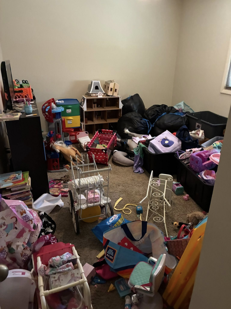 A cluttered bedroom filled with toys, bags, and various items, representing a 'before' scene for house cleaning by Royalty Cleaning LLC in Fresno, CA.