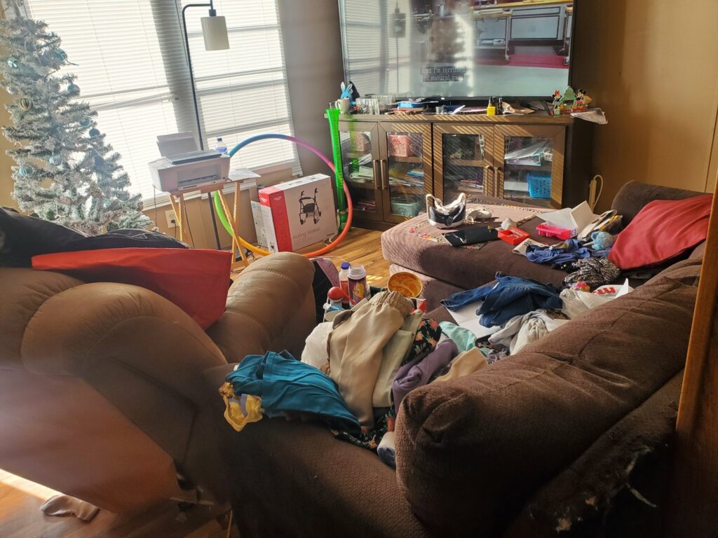 Another view of a cluttered living room before professional cleaning by Chelle's Cleaning Services in Gary, IN.