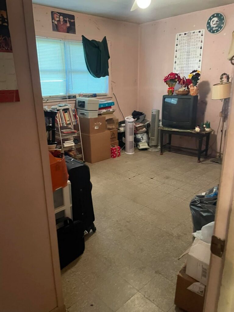 A cluttered room with boxes and a dirty floor, showing a space before house cleaning by Skedaddle Cleaning Services in Eufaula, AL.