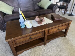 A coffee table with a spray bottle and duster, indicating house cleaning services by Deschutes Cleaning in Bend, OR.