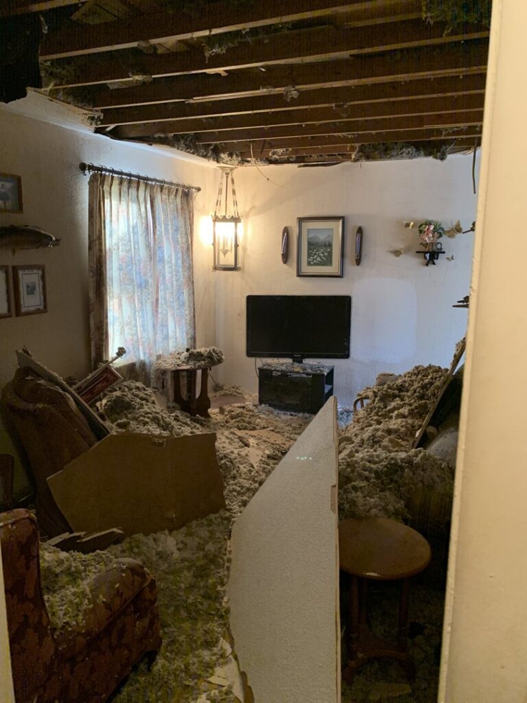 A room with a collapsed ceiling and debris on the floor due to severe water damage, remediated by Service Professionals in Edmond, OK.