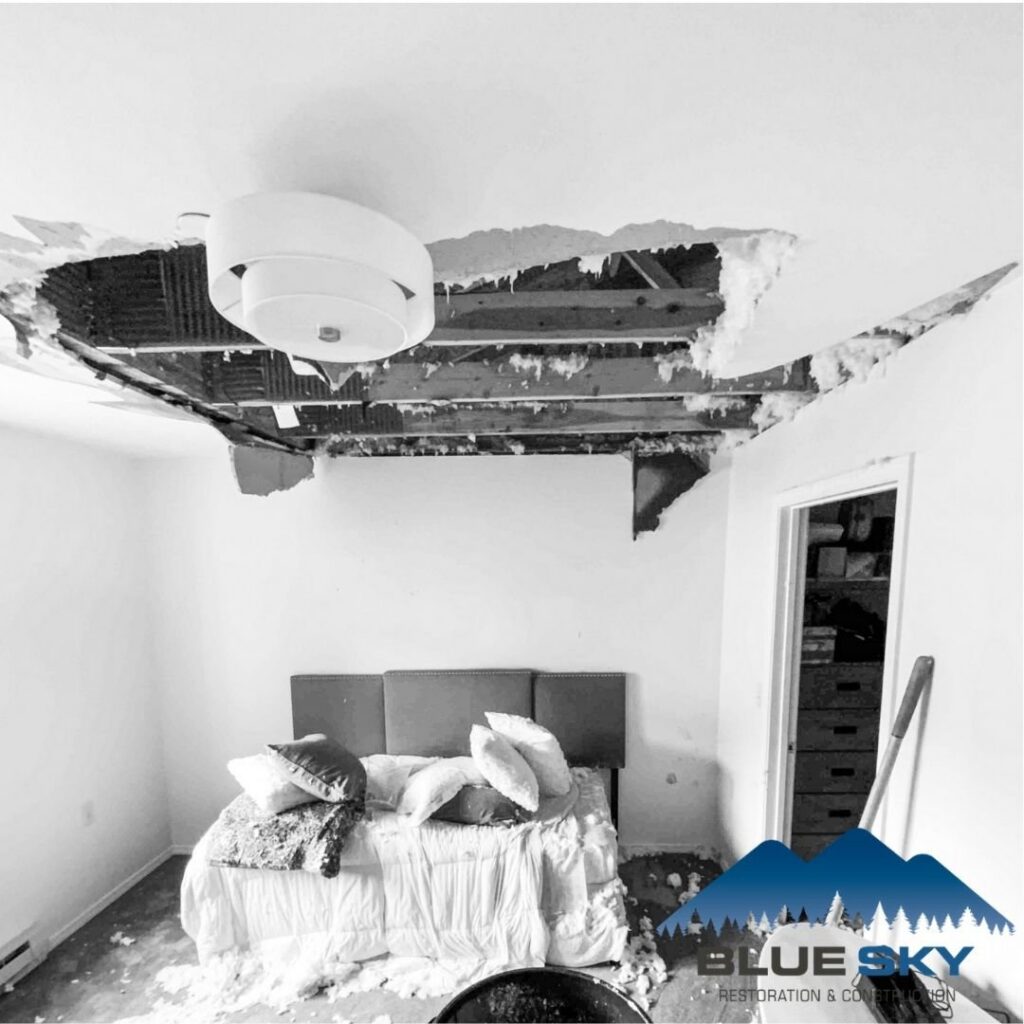 A bedroom with a collapsed ceiling due to water damage, awaiting restoration by Clear Sky Restoration & Construction in Jackson, WY.